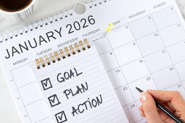 January 2026 new year goal, plan, action, handwritten inspirational checklist text in notebook with coffee cup. Top view. Personal growth, business progress and success concept.