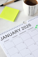 January first 2026 new year calendar date with a pin on white table with coffee cup and sticky notes. Business goals reminder, annual planning concept.