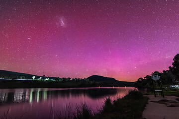Aurora Australis display lights up the sky in pinks over the dam