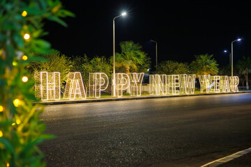 Illuminated happy New Year sign on street