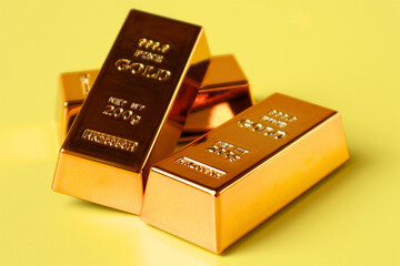 Stack of gold bars on yellow background