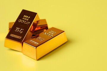 Stack of gold bars on yellow background