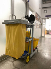 A yellow trolley filled with cleaning equipment for the office cleaning staff.