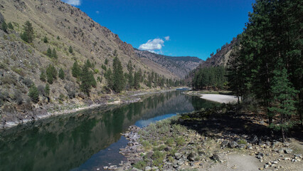 drone photo of Salmon River Canyon upstream from Riggins ID with white sandy beaches and beautiful clear reflection of the canyon walls and blue sky