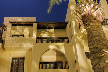 Tropical resort building with palm tree at night