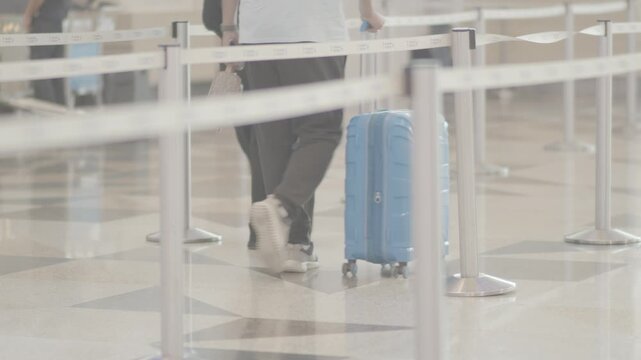Traveler walking with blue suitcase at King Abdulaziz International Airport (JED) in Jeddah, Saudi Arabia