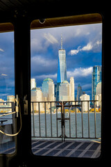 Lower Manhattan skyline from ferry on Hudson River under dramatic clouds