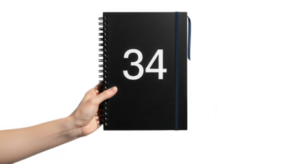 Hand holding a black spiral notebook with number thirty four on transparent