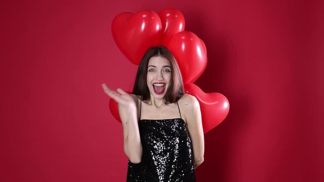 St. Valentine's Day. Beautiful woman with heart shaped balloons on red background
