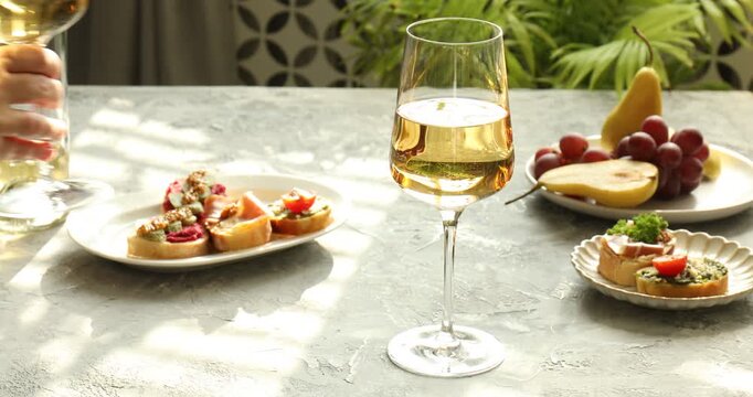 People taking bruschette, wine and fruit from table, closeup