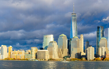 Panoramic Lower Manhattan skyline over Hudson River under dramatic clouds in NYC