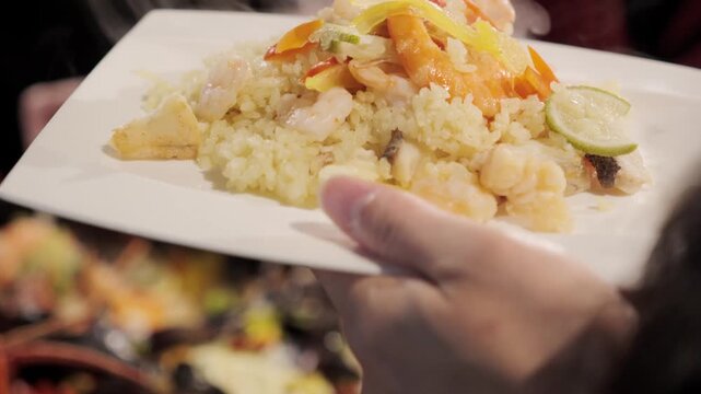 レストラン　皿にパエリア米料理をとる　料理・パーティーの食事　米料理　