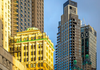 Historic skyscraper in downtown Manhattan with ornate facade under warm sunlight