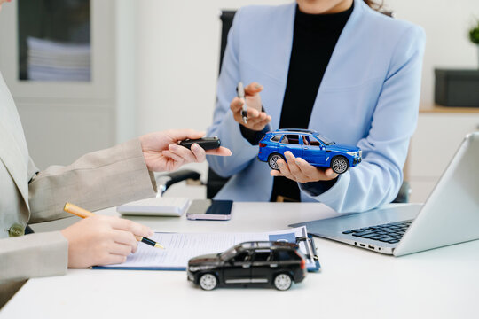 Car insurance consultation using smartphone and documents. Advisor and customer reviewing digital insurance service, auto policy, finance, technology - Powered by Adobe