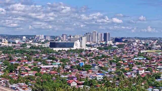 Davao City in Mindanao Philippines, panning aerial showing the City of Davao with contrasting downtown houses and modern tower blocks