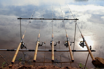 A row of fishing rods was lined up with fish in a reservoir in the countryside.