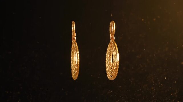 closeup of a pair of gold earrings spinning with glitter dust trails