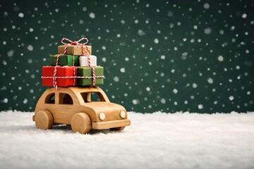 Classic wooden car carrying stacked red and green wrapped gifts, winter celebration and festive snow scene, ideal for xmas greeting cards retail marketing