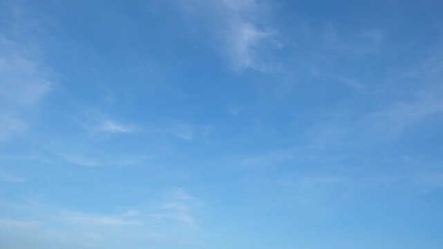 A calming blue sky timelapse video featuring soft, wispy clouds drifting gently across a clear atmosphere, symbolizing tranquility, freedom, and the natural beauty of ever-changing cloud formations.
