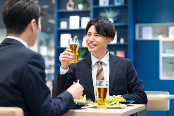 飲食店でビールを飲む若いビジネスマン