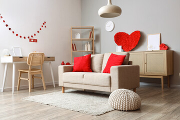 Interior of living room decorated for Valentine's Day with sofa, workplace and hearts