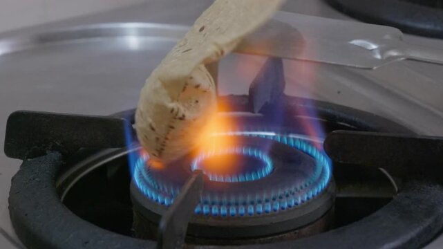 Person failed to make phulka on gas stove flame at home. internal shot, stable shot, 4k.