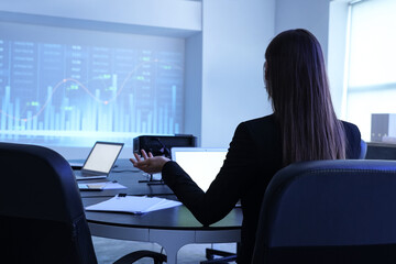 Female data scientist working with laptop at workplace in office, back view