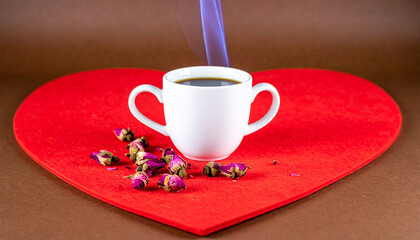 White Coffee Cup with Handles on Red Heart Surrounded by Dried Rosebuds image photo
