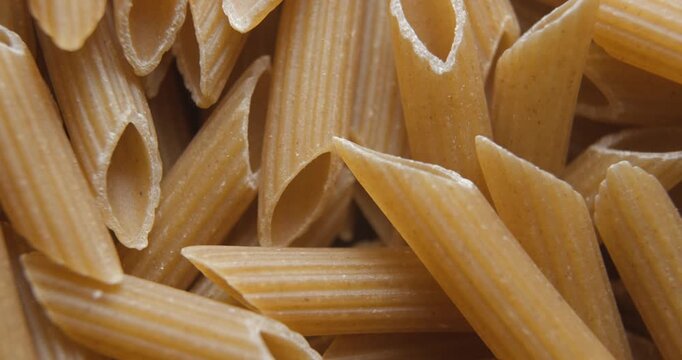 Penne pastas whole-grain close up studio shot over rotating