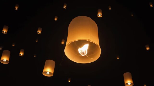 Floating lanterns illuminating the night sky during a festival celebration