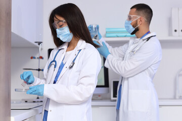 Young doctors with chemical equipment analyzing scientific data in laboratory