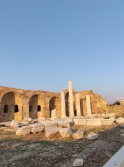 Obraz premium Ancient roman ruins at sunset with pillars and arches in historical landscape