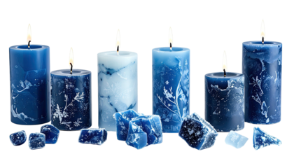 Lit, patterned, blue pillar candles and wax chunks on black background