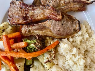 Grilled lamb chops, roasted vegetables and couscous isolated on a plate