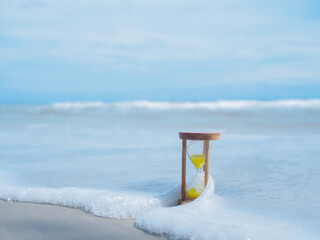 Hourglass on the beach. The concept about countdown to Summer, Travel, Vacation and Relaxation.