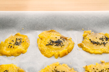 押し付けた蜜芋にバターを塗ってゴマをのせる © kikisora