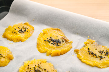 押し付けた蜜芋にバターを塗ってゴマをのせる © kikisora