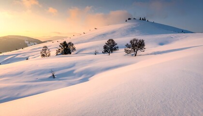 Snow-covered mountain slopes bathed in the warm light of sunrise, trees scattered
