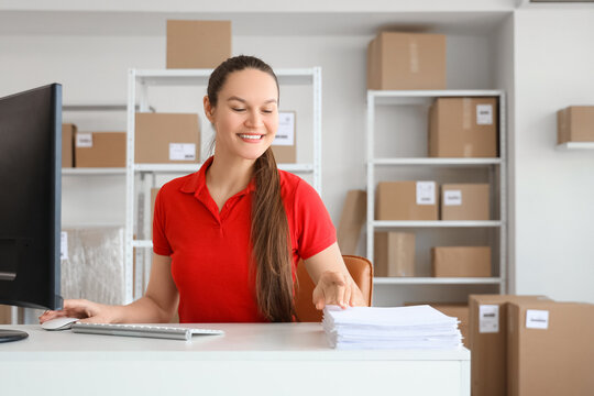 Female worker working at table in warehouse - Powered by Adobe