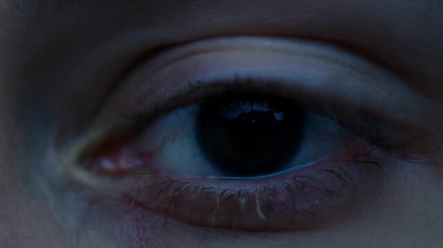 Dilated pupil in extreme close up blinking slowly