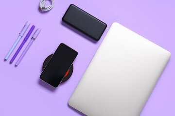 Composition with modern gadgets and pens on lilac background