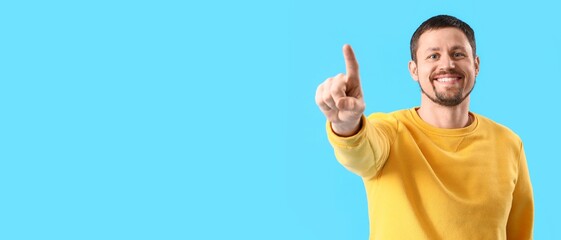 Naklejka premium Happy man using virtual screen on blue background. Banner for design