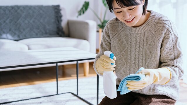 テーブルの上を洗剤と布で掃除する日本人女性