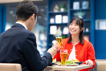 飲食店でビールを飲む男女