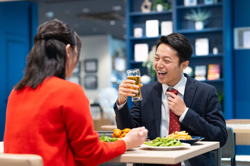 女性とビールを飲むミドルのビジネスマン
