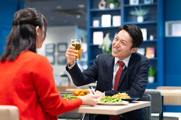 女性とビールを飲むミドルのビジネスマン