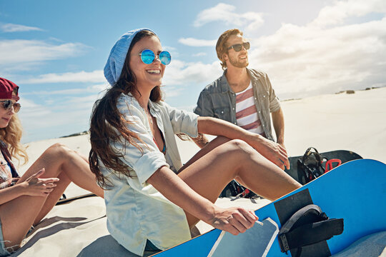 Break, hobby and sand board with friends outdoor on dunes for adventure activity or extreme sports. Relax, smile and vacation with group of sandboarding people in nature for holiday, travel or trip