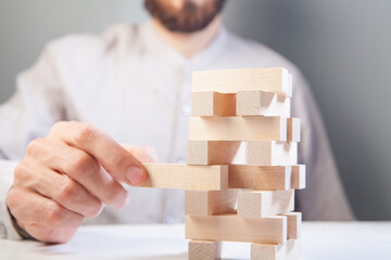 businessman putting wooden blocks on wooden blocks as concept of strategy and business success.