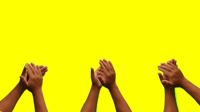 Hands clapping on yellow screen background. Victory and award concept 