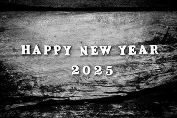 Dramatic black and white flat lay of "Happy New Year 2025" wooden letters on a textured rustic wood background. High contrast monochrome aesthetic for classic holiday greetings and artistic countdowns